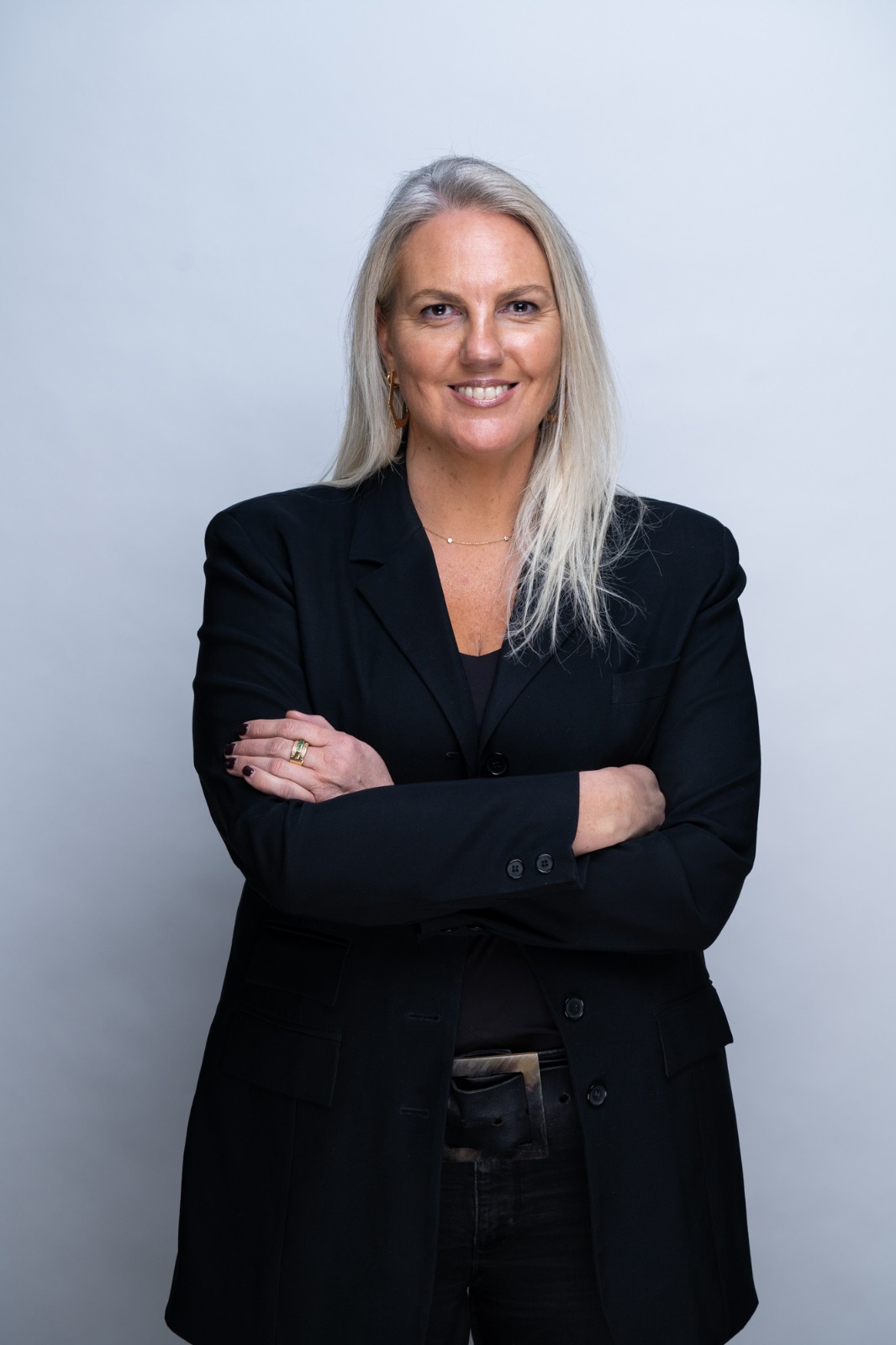 Retrato de M. Francisca Cáraves Lyng, Managing Partner y Fundadora de FIT People & Business, de brazos cruzados, con chaqueta negra sobre fondo gris claro.